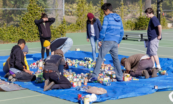 Garden Street Academy Students Assembling Canned Food Mosaic Art Piece